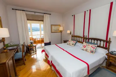 a bedroom with a large white bed and a window at Parador de Ribadeo in Ribadeo