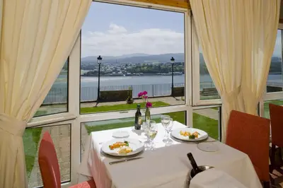 a table with two plates of food and a large window at Parador de Ribadeo in Ribadeo