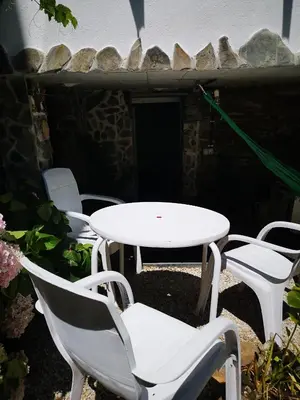 a group of white chairs and a white table and chairs at Pensión Santa Rosa in Samos