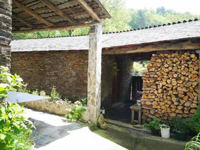 a brick building with a pile of fire wood at Pensión Santa Rosa in Samos