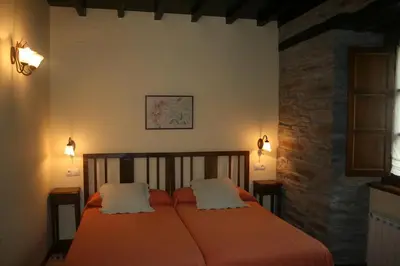 a bedroom with a bed with two pillows on it at Apartamentos Rurales El Palacio de Doiras in Boal