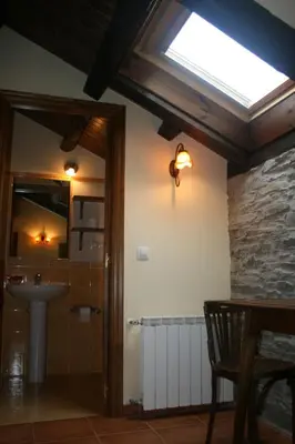 a bathroom with a sink and a skylight at Apartamentos Rurales El Palacio de Doiras in Boal