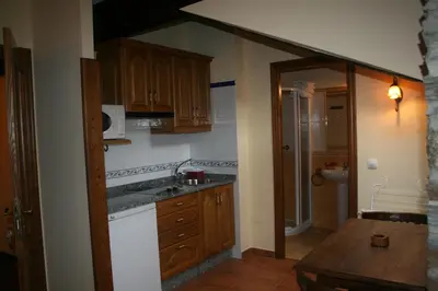 a kitchen with wooden cabinets and a sink at Apartamentos Rurales El Palacio de Doiras in Boal
