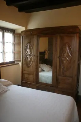 a bedroom with a large wooden cabinet with a bed at Apartamentos Rurales El Palacio de Doiras in Boal