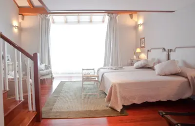 a bedroom with a bed and a large window at Inicia Cruceiro do Galo in Santiago de Compostela