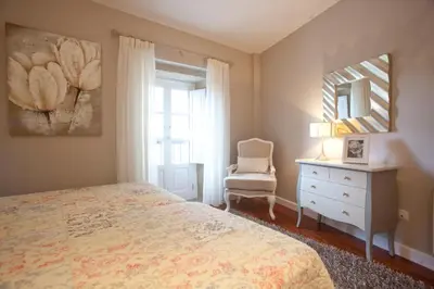 a bedroom with a bed and a dresser and a mirror at Inicia Cruceiro do Galo in Santiago de Compostela