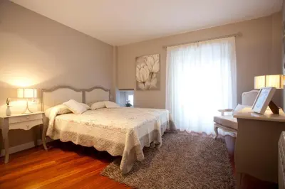 a bedroom with a bed and a large window at Inicia Cruceiro do Galo in Santiago de Compostela