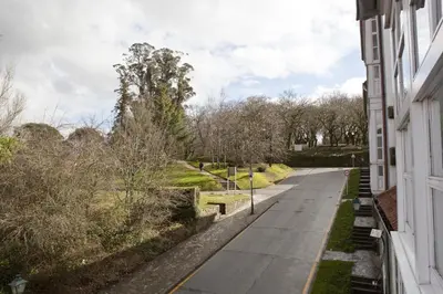 an empty street in a park with trees at Inicia Cruceiro do Galo in Santiago de Compostela