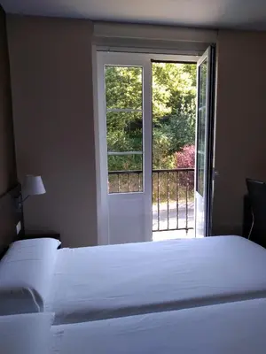 a bedroom with a large bed and a window at Pensión Lemos in Tríacastela