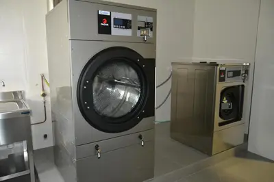 a kitchen with a stainless steel refrigerator and a microwave at Pensión Lemos in Tríacastela