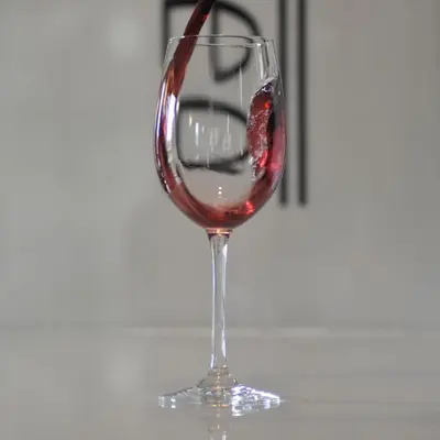 a glass of red wine being poured into it at Pons Minea in Portomarin