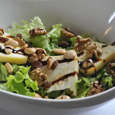 a salad with tofu and nuts in a white bowl at Pons Minea in Portomarin