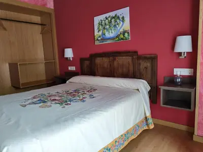 a bedroom with a white bed with red walls at Via Stellae in Tamallancos