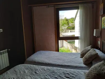 two beds in a room with a window at Via Stellae in Tamallancos