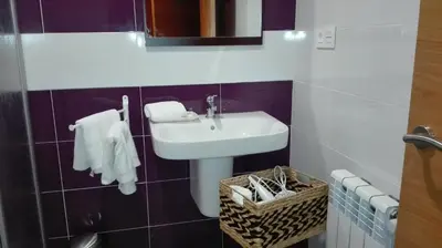 a bathroom with a sink and a basket with towels at Via Stellae in Tamallancos