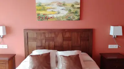 a bedroom with a bed with a painting on the wall at Via Stellae in Tamallancos