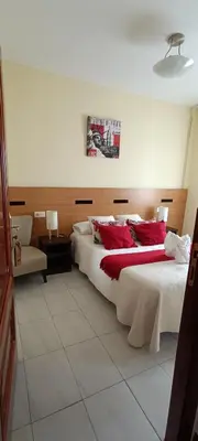 a bedroom with a large bed with red pillows at Pensión Mar in Portomarin