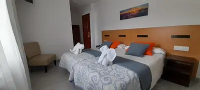 a bedroom with two beds with white towels on them at Pensión Mar in Portomarin