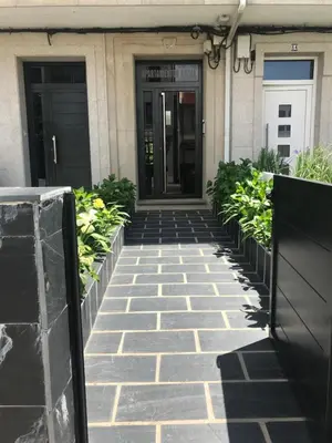 a walkway leading to a building with two doors at Viviendas Uso Turístico Arzúa in Arzúa