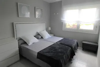 a bedroom with a bed and two windows at Viviendas Uso Turístico Arzúa in Arzúa