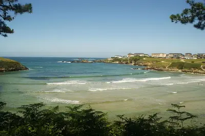 a view of a beach with people in the water at Apartamentos Navalin in Tapia de Casariego