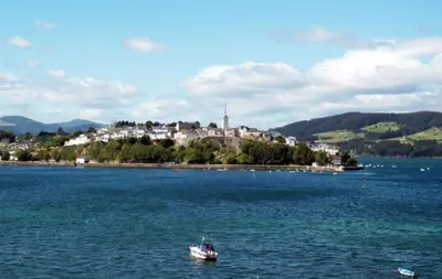 a small boat in the middle of a large body of water at Apartamentos Navalin in Tapia de Casariego