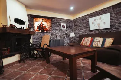 a living room with a couch and a fireplace at Apartamentos Rurales Los Galpones in Coaña