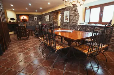 a dining room with a wooden table and chairs at Apartamentos Rurales Los Galpones in Coaña