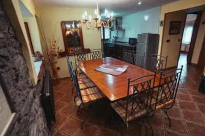 a dining room with a table and a kitchen at Apartamentos Rurales Los Galpones in Coaña