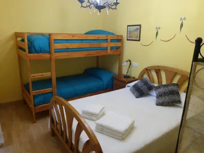 a bedroom with a bunk bed and a blue couch at Apartamentos Rurales Los Galpones in Coaña
