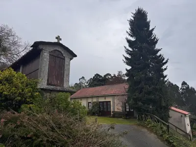 an old building with a tower and a pine tree at Casa Rural A Cobacha in Paderne