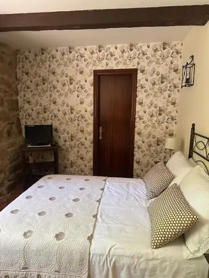 a bedroom with a bed and a wooden door at Casa Rural A Cobacha in Paderne