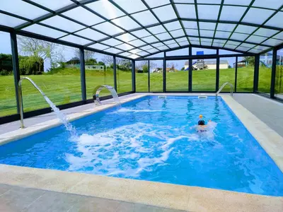 a person swimming in a swimming pool with a large outdoor swimming poolvisor at Hotel La Casa Del Abuelo in Tapia de Casariego