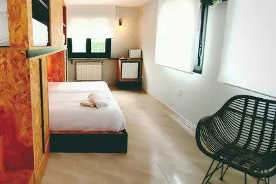 a bedroom with a bed and a chair in it at Hotel La Casa Del Abuelo in Tapia de Casariego