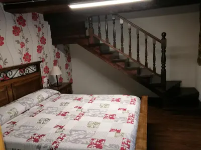 a bedroom with a bed and a staircase at Casa de los Somoza in Melide