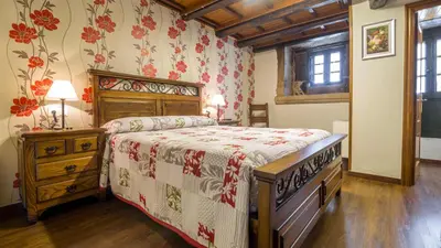 a bedroom with a bed and a dresser in it at Casa de los Somoza in Melide