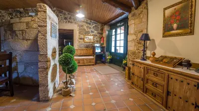a living room with a stone wall at Casa de los Somoza in Melide