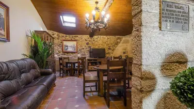 a living room with a couch and a table and chairs at Casa de los Somoza in Melide
