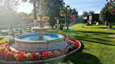 a fountain in the middle of a park with flowers at Casa de los Somoza in Melide
