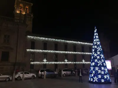 a christmas tree in front of a building with lights at Hotel Celanova in Celanova