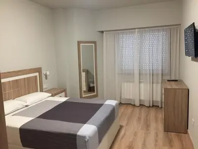 a bedroom with a bed and a large window at Hotel Celanova in Celanova