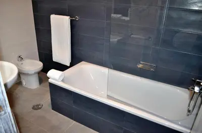 a bathroom with a bath tub and a toilet at Hotel Celanova in Celanova