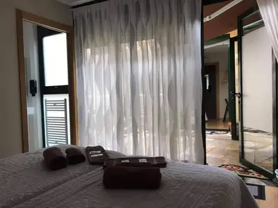 a bedroom with a bed and a large window at Pension Siete en el Camino in Sarria