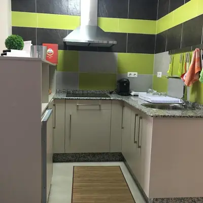 a kitchen with green and yellow stripes on the wall at Pension Siete en el Camino in Sarria