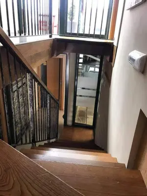 a stairway with a wooden railing and a stair case at Pension Siete en el Camino in Sarria