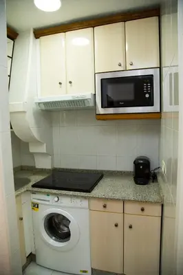 a kitchen with a microwave and a washing machine at Xavestre Rooms Santiago in Santiago de Compostela