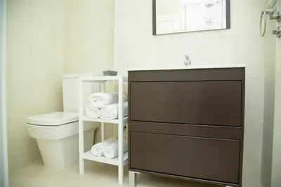 a bathroom with a sink and a toilet and towels at Xavestre Rooms Santiago in Santiago de Compostela