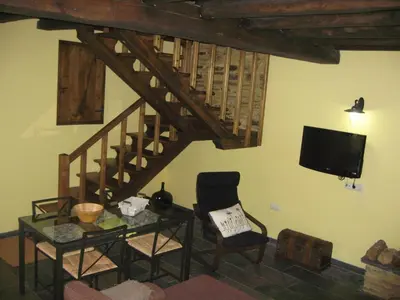 a living room with a tv and a table and chair at Casa Carballeira in Villarfernando