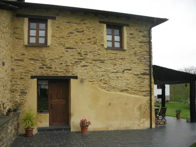 a stone house with a door and a patio at Casa Carballeira in Villarfernando