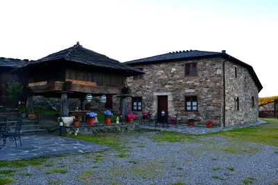 a large stone building with a building with a porch at Apartamentos Rurales RON in Ron